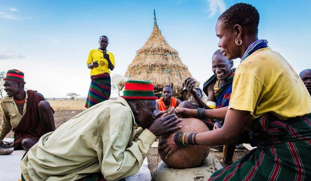 Karamojong elders and villagers gathered at a homestead in Karamoja, north-eastern Uganda