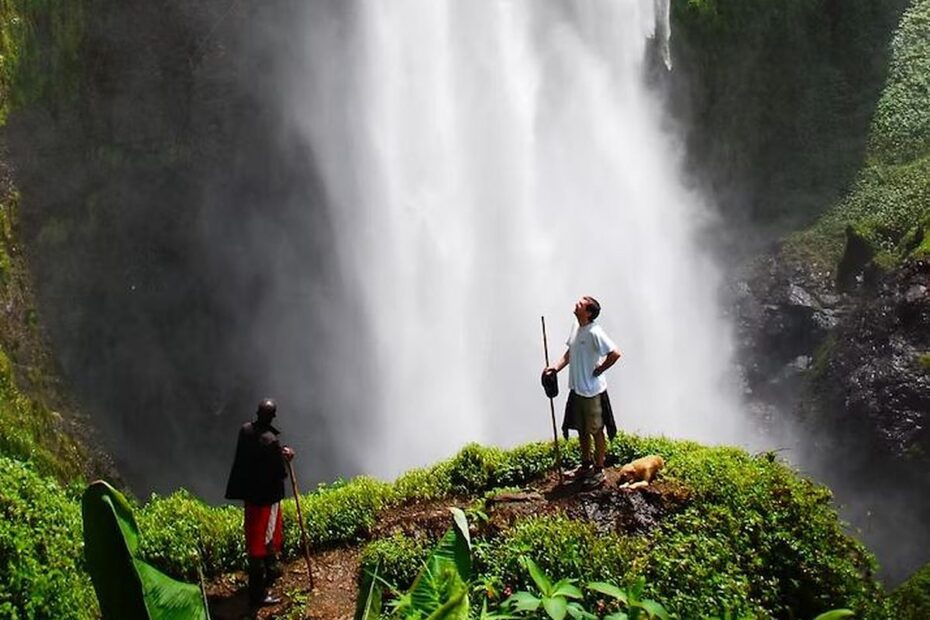 Sipi Falls Uganda: Waterfalls, Hikes and Coffee Tours on Mount Elgon Sipi Falls Uganda: a guide and hiker at the base of the main 100-metre waterfall